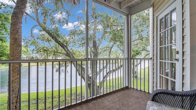 unfurnished sunroom with a water view