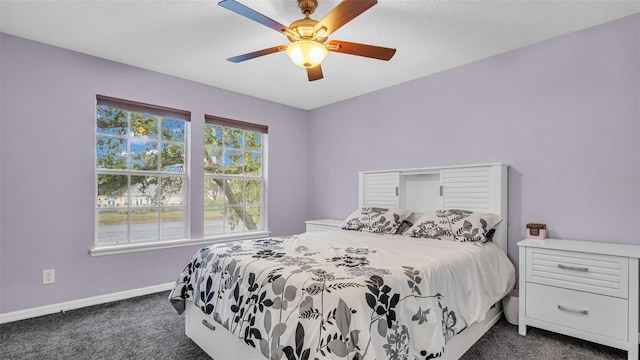 bedroom with ceiling fan and dark carpet