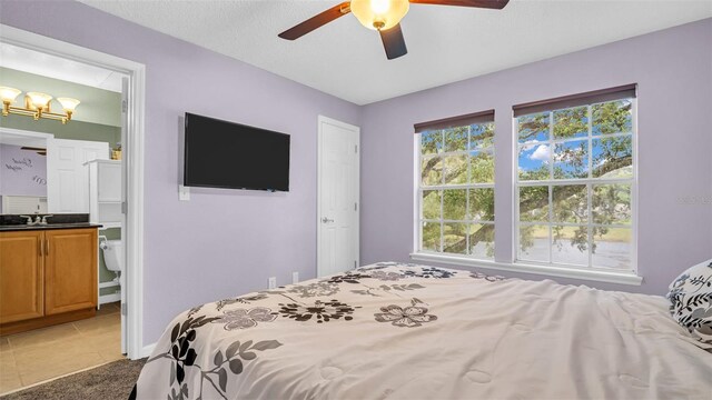 bedroom featuring light tile patterned flooring, sink, and ceiling fan