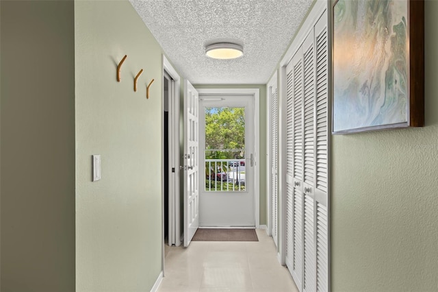 entryway featuring a textured ceiling and light tile patterned floors