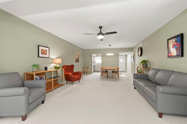 carpeted living room featuring ceiling fan