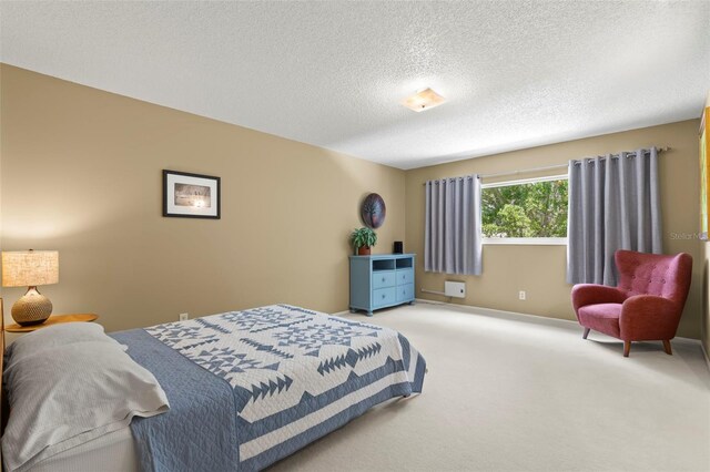 bedroom featuring a textured ceiling and light colored carpet