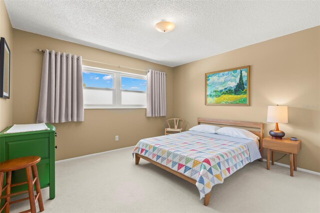 bedroom featuring light colored carpet and a textured ceiling