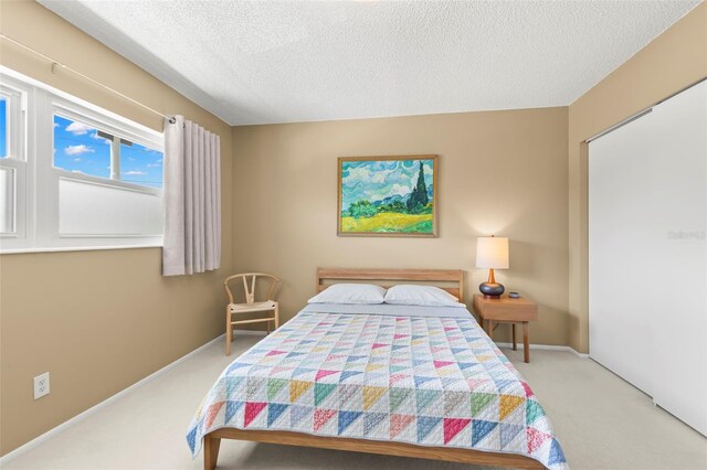 carpeted bedroom featuring a closet and a textured ceiling