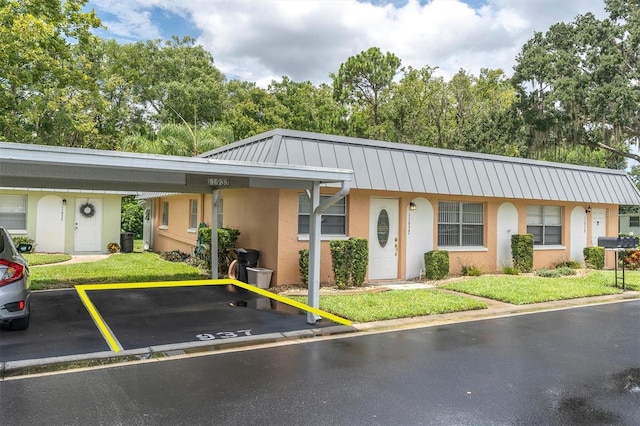 ranch-style house with a carport and a front yard