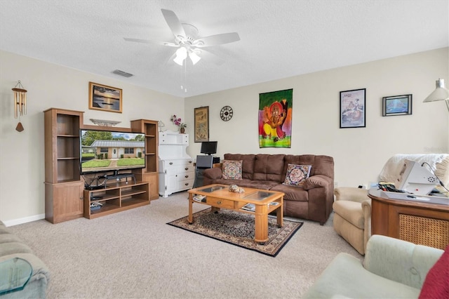 carpeted living room with ceiling fan and a textured ceiling