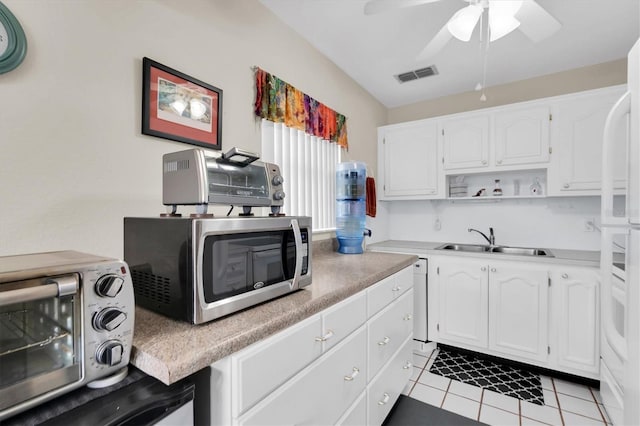 kitchen featuring white cabinetry, sink, light tile patterned floors, and ceiling fan