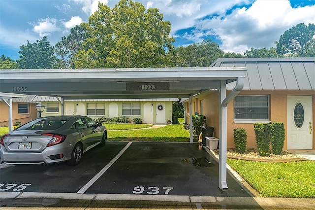 view of vehicle parking with a carport and a lawn