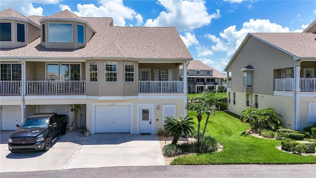 townhome / multi-family property with a balcony, a garage, and a front lawn