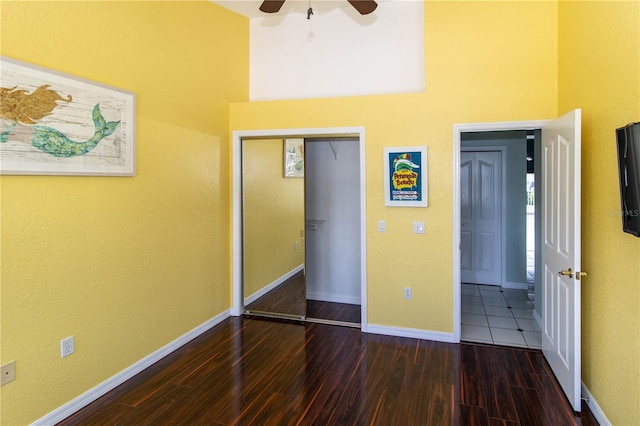 unfurnished bedroom featuring a closet, dark hardwood / wood-style flooring, and ceiling fan