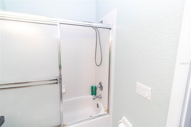 bathroom featuring combined bath / shower with glass door