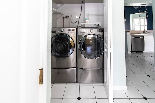 washroom featuring separate washer and dryer, sink, and light tile patterned flooring