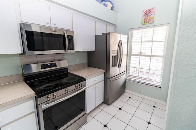 kitchen featuring appliances with stainless steel finishes, a wealth of natural light, and white cabinetry