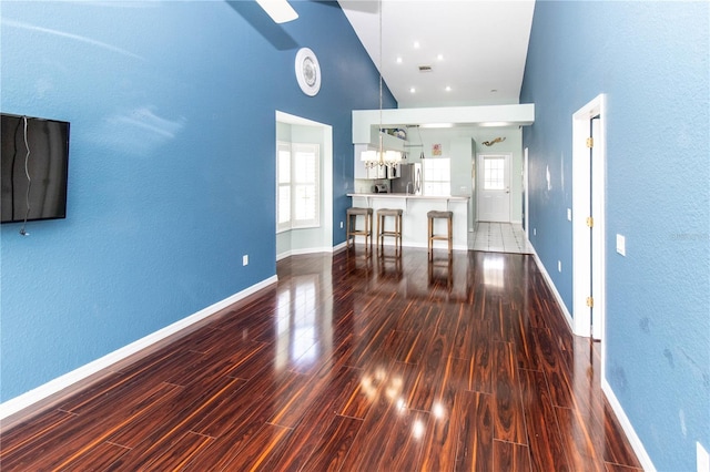 unfurnished living room featuring dark hardwood / wood-style flooring and a high ceiling