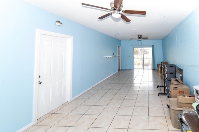 empty room with ceiling fan and light tile patterned floors