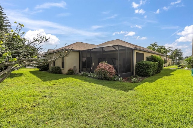 rear view of house featuring a lawn, a lanai, and stucco siding