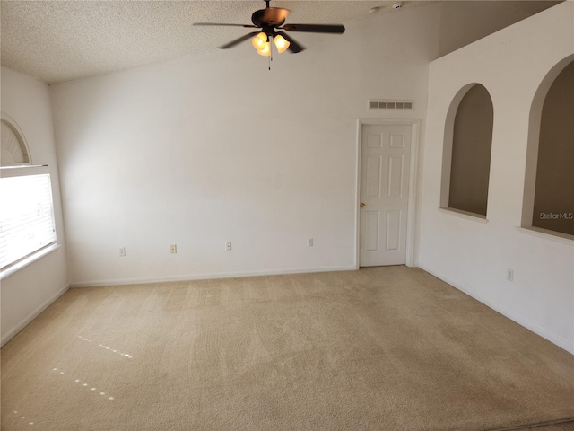 empty room featuring light carpet, ceiling fan, and a textured ceiling