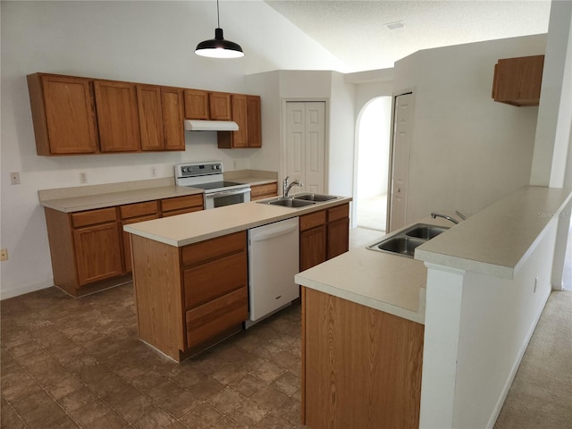 kitchen featuring pendant lighting, sink, white appliances, and a center island with sink