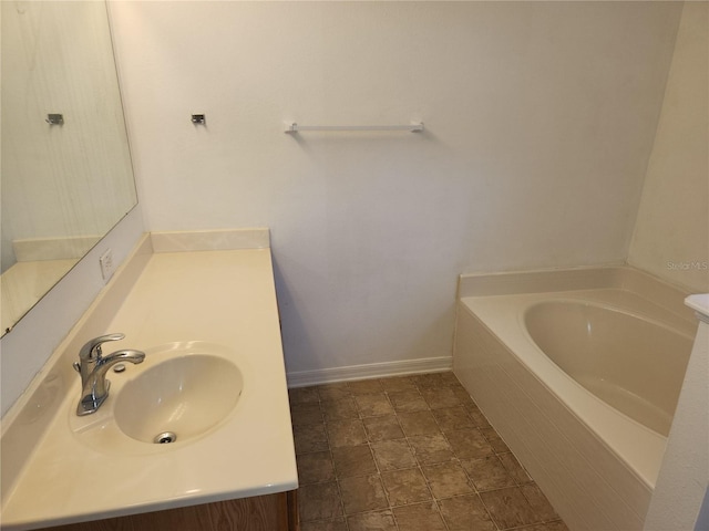 bathroom with a relaxing tiled tub and sink