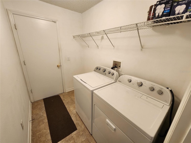 washroom featuring separate washer and dryer and a textured ceiling