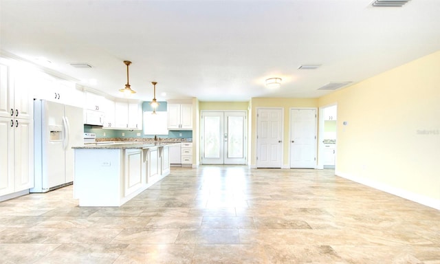 kitchen featuring hanging light fixtures, white cabinetry, light tile patterned floors, and white appliances