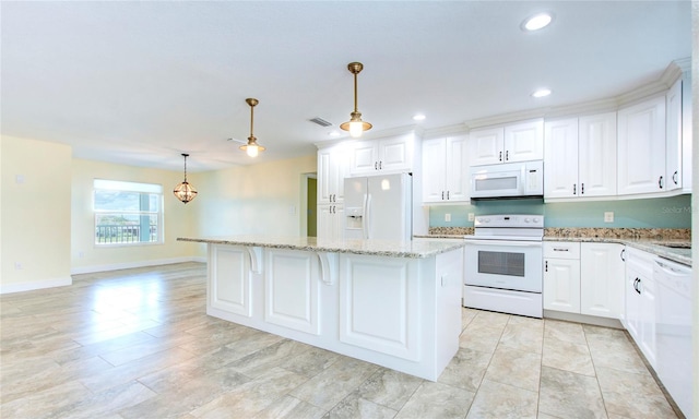 kitchen with white cabinetry, white appliances, light tile patterned floors, light stone countertops, and decorative light fixtures