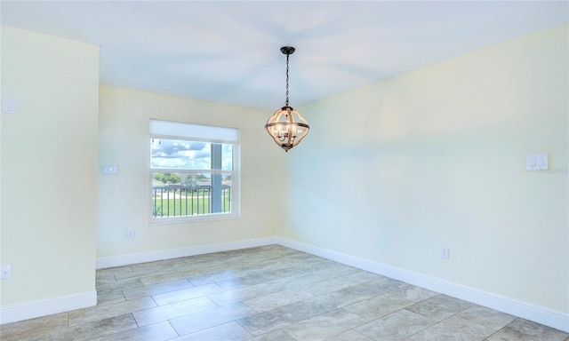 tiled spare room featuring an inviting chandelier