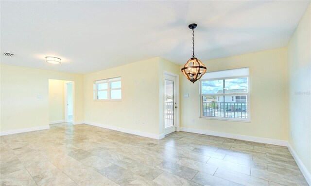 unfurnished room with light tile patterned flooring and an inviting chandelier