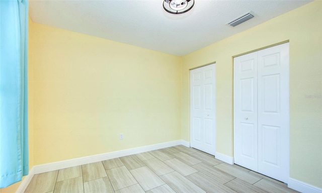 unfurnished bedroom with two closets