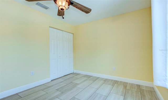 unfurnished bedroom with ceiling fan and a closet