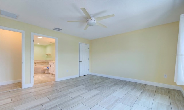 unfurnished bedroom with light tile patterned flooring, a closet, ensuite bathroom, and ceiling fan