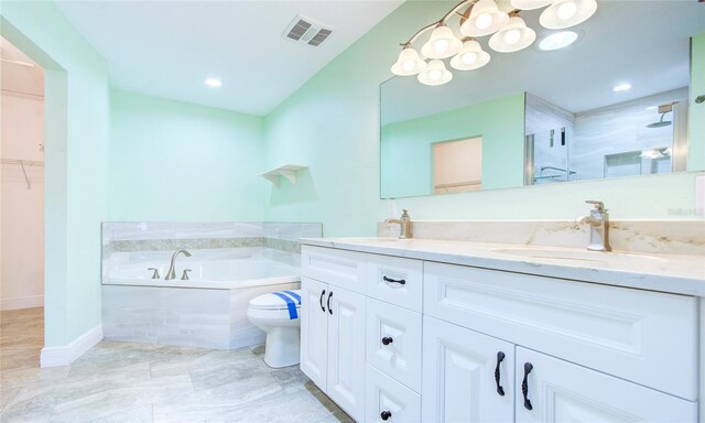 bathroom with dual vanity, a tub to relax in, tile patterned floors, and toilet