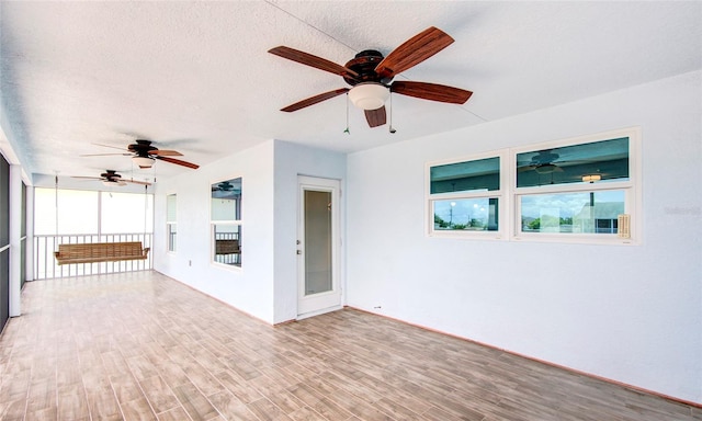 interior space with light hardwood / wood-style floors, a textured ceiling, and ceiling fan