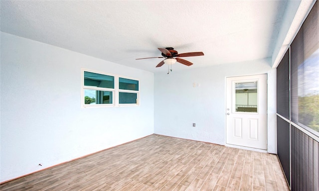 spare room with ceiling fan, a textured ceiling, and light hardwood / wood-style flooring