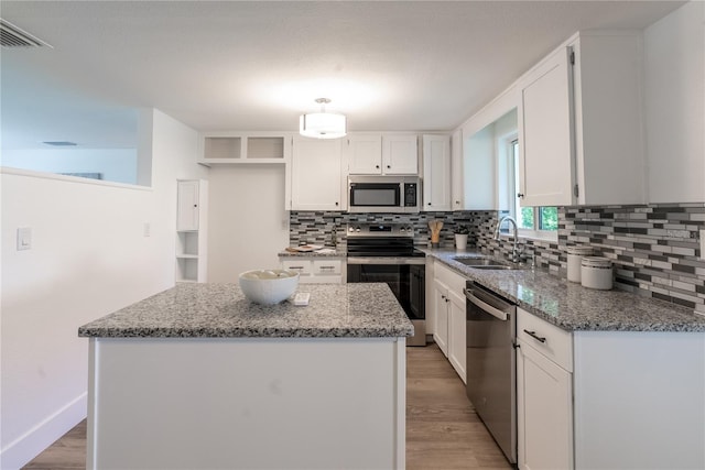 kitchen with white cabinets, light hardwood / wood-style floors, appliances with stainless steel finishes, and sink