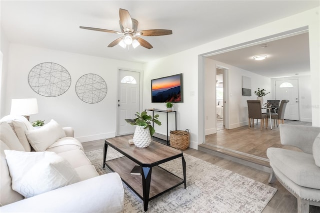 living room with light hardwood / wood-style flooring and ceiling fan