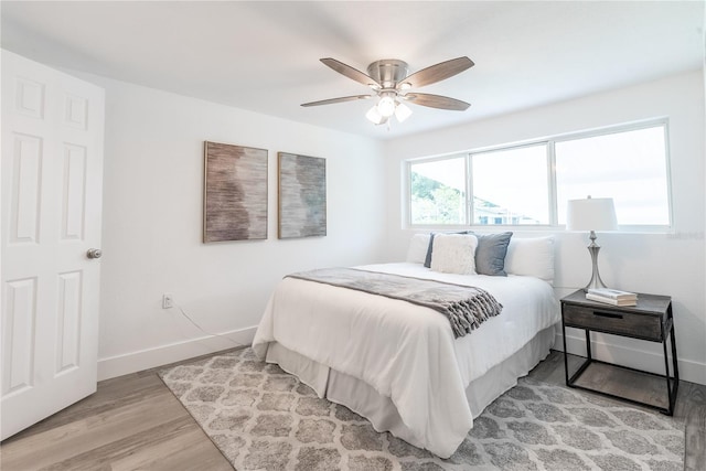 bedroom with light hardwood / wood-style floors and ceiling fan