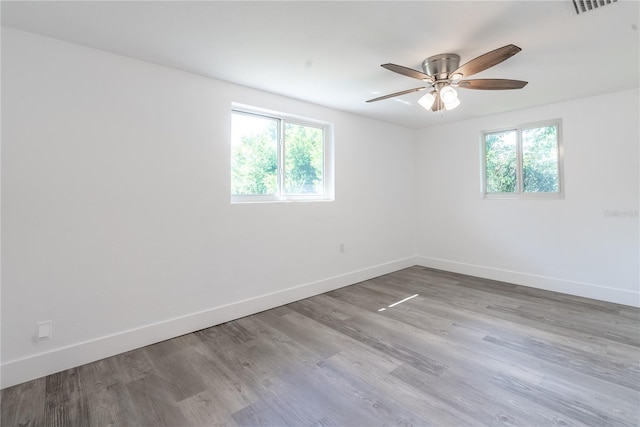 empty room with light wood-style flooring, baseboards, and a ceiling fan