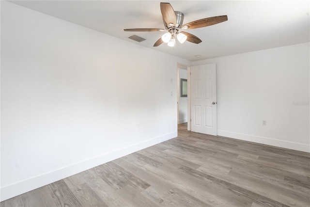 empty room featuring a ceiling fan, visible vents, light wood-style flooring, and baseboards