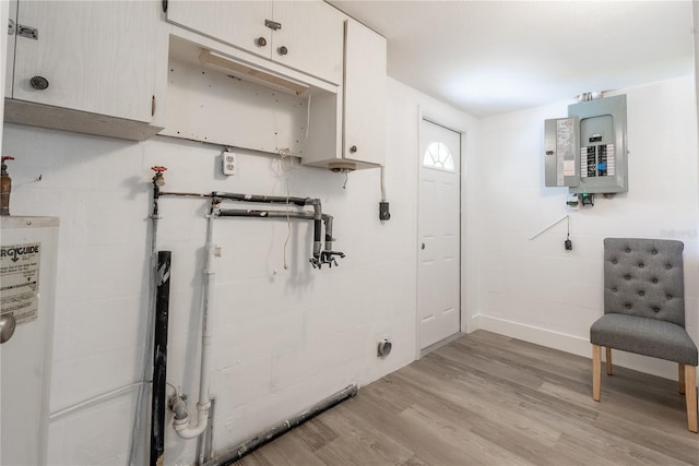 interior space with light hardwood / wood-style floors, electric panel, and water heater