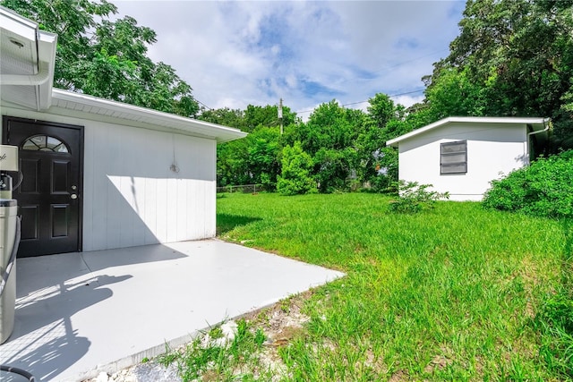 view of yard with an outbuilding and a patio