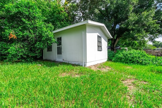 view of outdoor structure with fence and an outbuilding