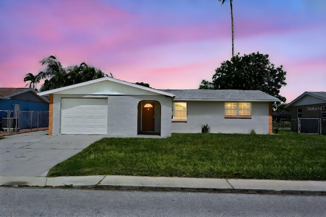 single story home with a garage and a yard