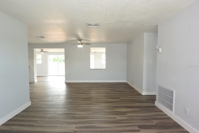 spare room with a textured ceiling, ceiling fan, and dark hardwood / wood-style floors