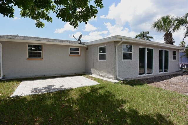 rear view of house with a patio and a yard