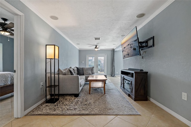 tiled living room featuring a textured ceiling, french doors, ornamental molding, and ceiling fan