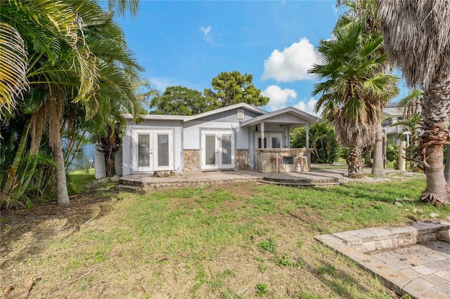 back of property featuring a patio, french doors, and a yard