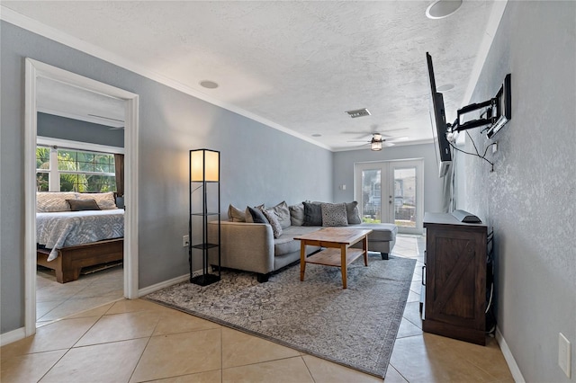 tiled living room featuring ceiling fan, a textured ceiling, french doors, and plenty of natural light