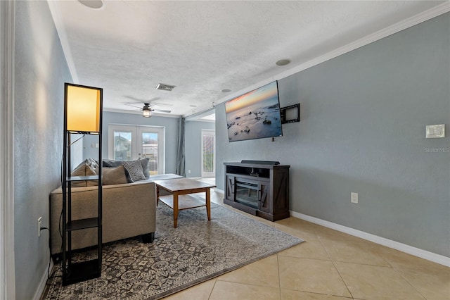 living room with a textured ceiling, french doors, light tile patterned floors, and ceiling fan