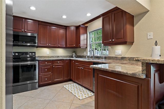 kitchen with dark stone countertops, light tile patterned floors, stainless steel appliances, sink, and ornamental molding